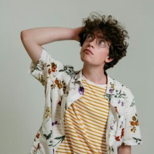 Caucasian man with curly hair and eyeglasses pensively looking up in a studio shot.